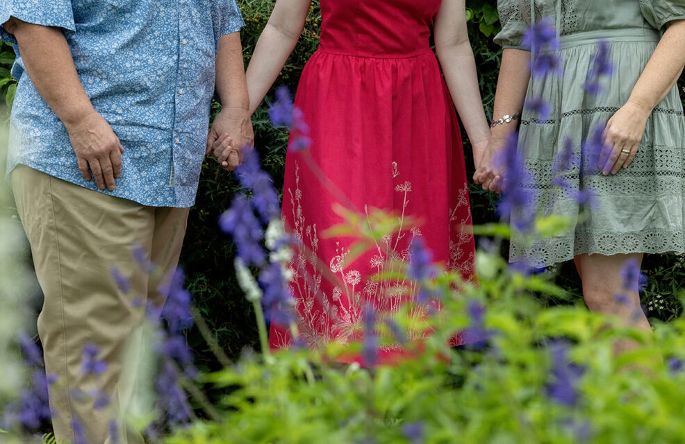 family holding hands in flowers