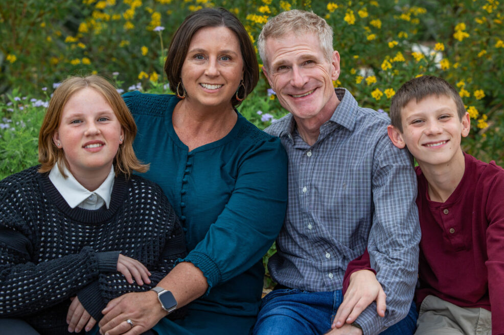 family of four in front of yellow flowers for their holiday photo session